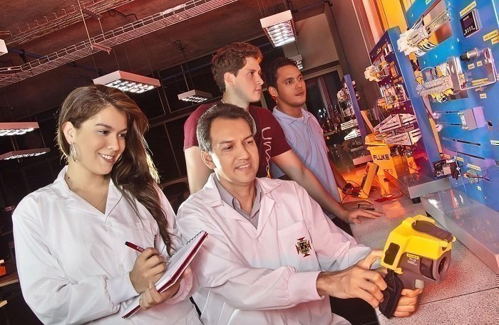 Personas trabajando en un sistema de cableado eléctrico con herramientas.