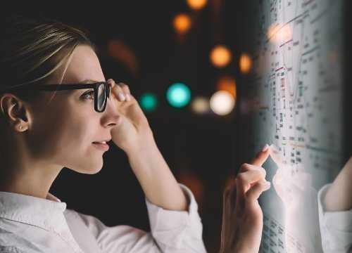 Mujer mirando de perfil un tablero con datos