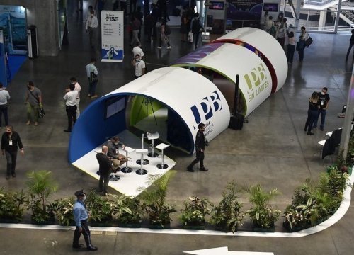 Personas caminando en medio de una exposición de trabajos de ingeniería eléctrica